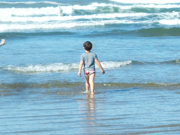 Little boy enjoying the waves on a 77 degree day on October 18, 2011 at Newport, OR beach